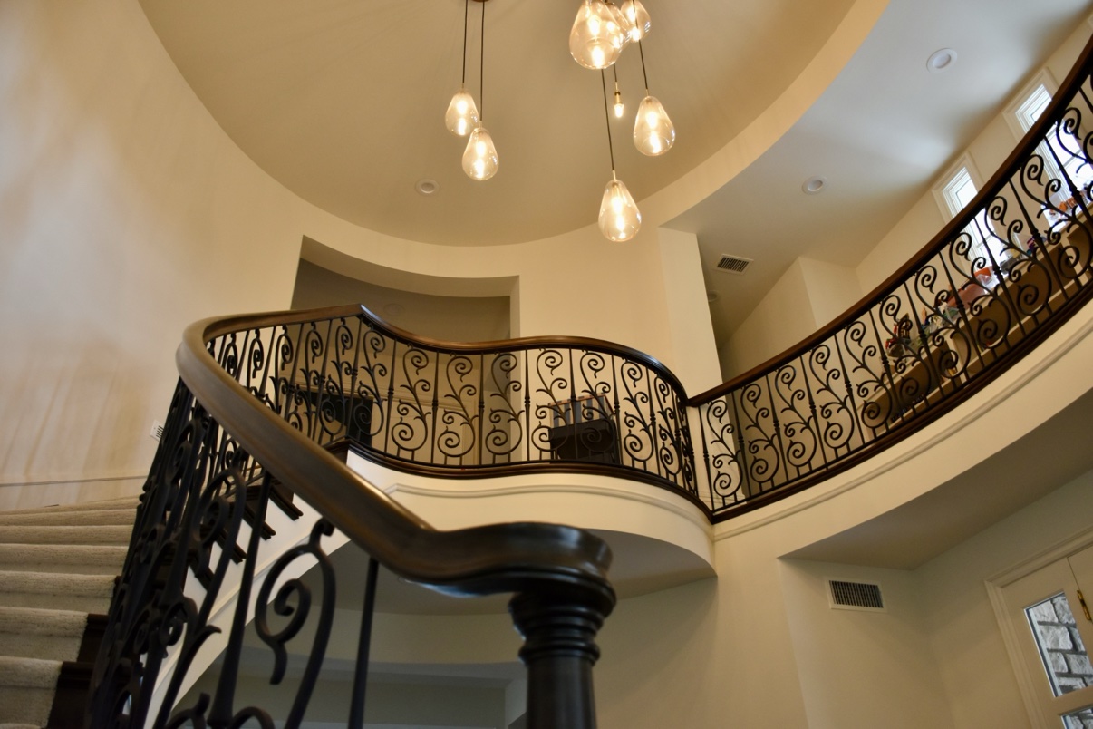 Circular staircase with scrolled wrought iron railing
